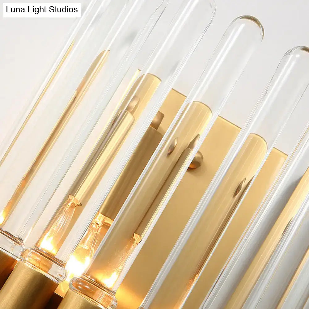 Modern brass finish clear crystal sconce lamp with gold-toned frame and warm glowing bulbs for bedroom lighting