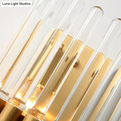 Modern brass finish clear crystal sconce lamp with gold-toned frame and warm glowing bulbs for bedroom lighting