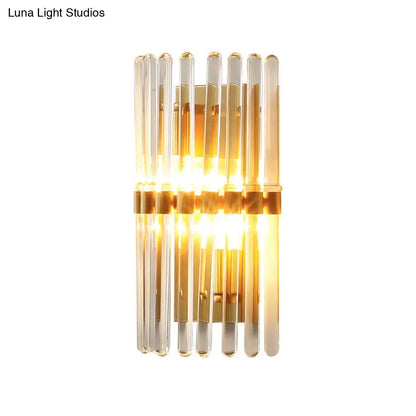 Modern brass finish clear crystal sconce lamp with vertical glass rods and gold-toned metal accents for bedroom lighting