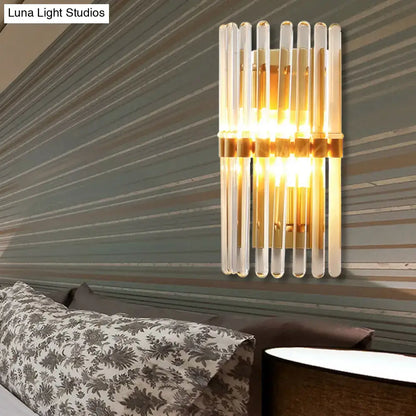 Modern brass finish clear crystal sconce lamp with clear glass tubes and gold-toned metal accents for bedroom use