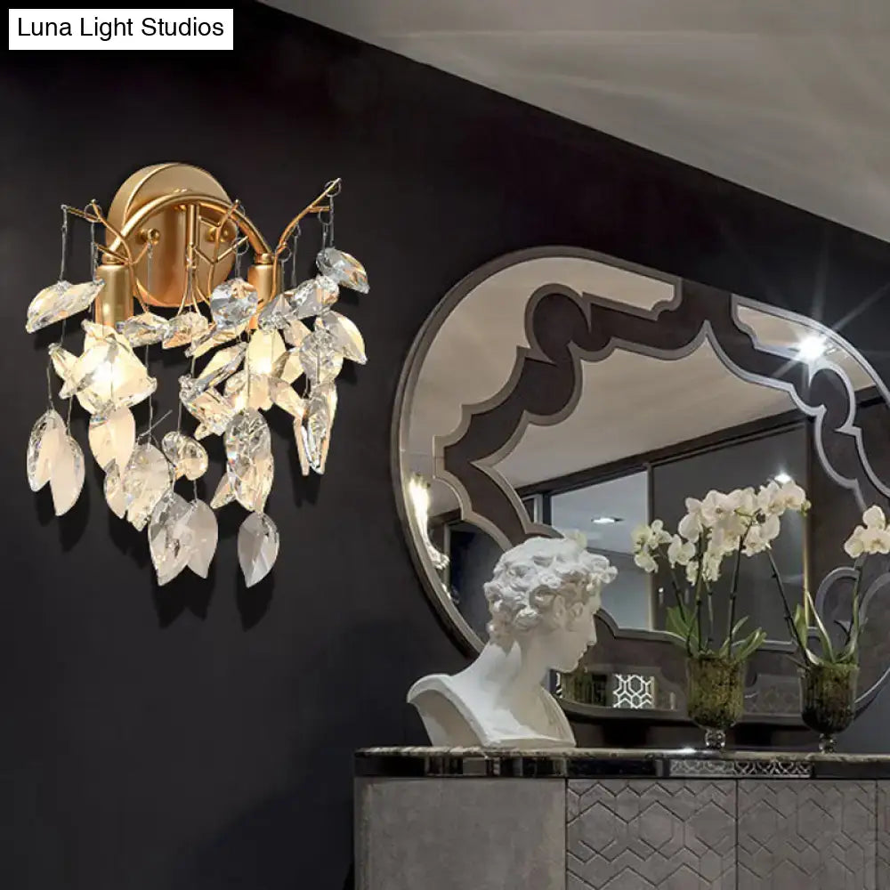 Modern brass finish wall light with gold-toned sconce and faceted crystal leaf light fixture for bedroom decor