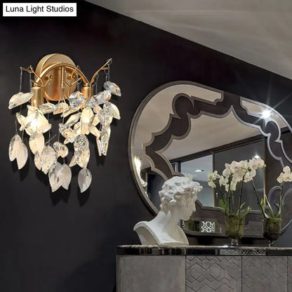 Modern brass finish wall light with gold-toned sconce and faceted crystal leaf light fixture for bedroom decor