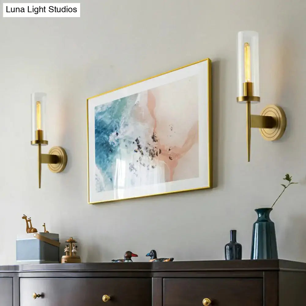 Modern brass finish glass tube wall light featuring a gold-framed abstract painting with blue pink and white swirls