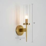 A sleek 16-inch tall brass finish glass tube wall light with a clear cylinder housing an illuminated bulb for living room use