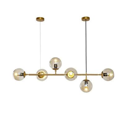 Modern brass pendant lights with six spherical glass globes and exposed filament bulbs for dining room use