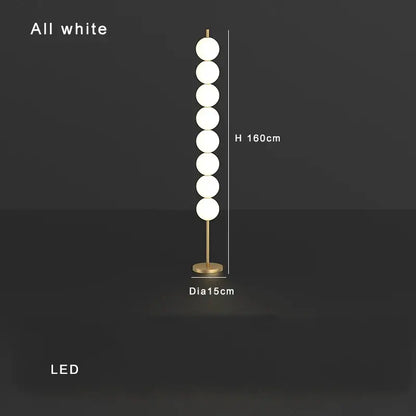 Modern brass floor lamp with seven white spherical bulbs and gold-toned decorbites brass floor lamp base