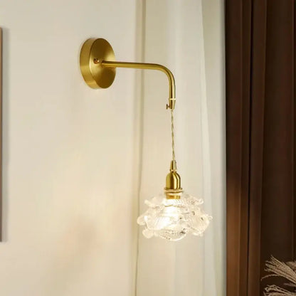 Modern brass flower led wall sconce with a gold-toned curved arm and ornate clear crystal glass shade for bedroom decorbites led wall lighting