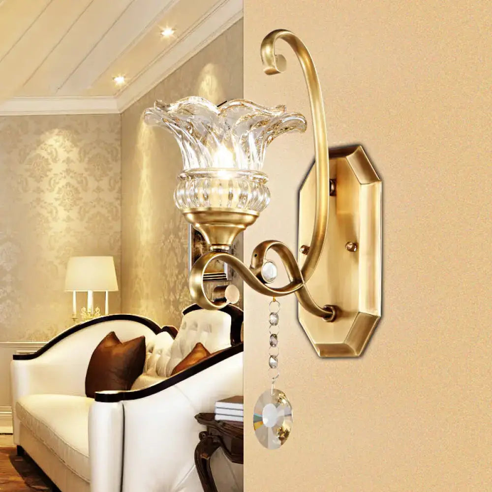 Modern brass flower sconce wall lamp with gold-toned light fixture and clear faceted glass shade with crystal accents