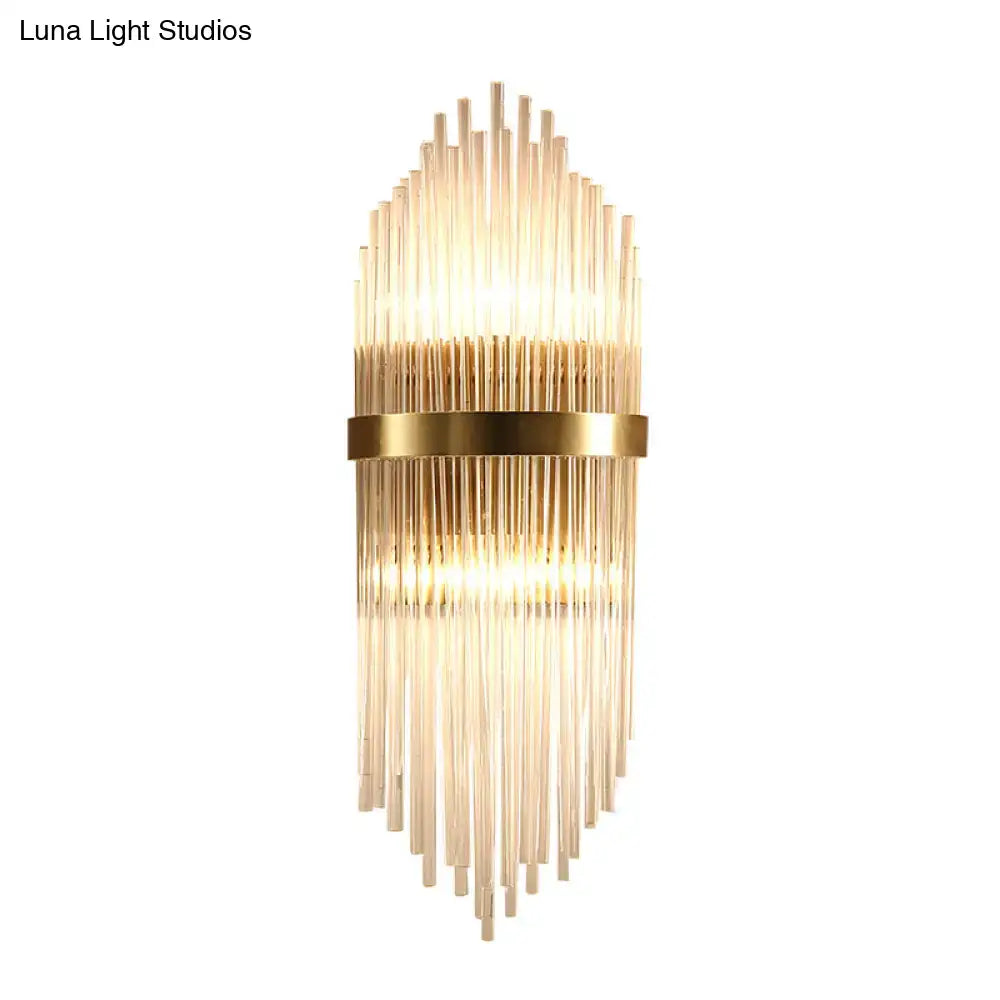 Gold-toned modern brass wall sconce with fluted glass shade and direct wired electric design for bedroom lighting