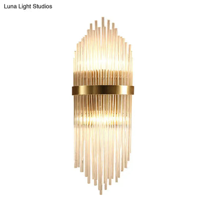 Gold-toned modern brass wall sconce with fluted glass shade and direct wired electric design for bedroom lighting