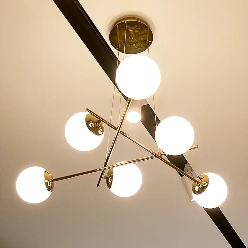 Modern brass french glass ball pendant light with six glowing white spherical shades for dining room decorbites french glass