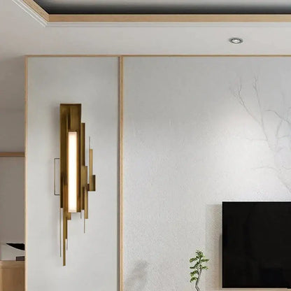Modern brass elegant wall lamp with gold-toned layered geometric design and vertical illuminated panel for living room use