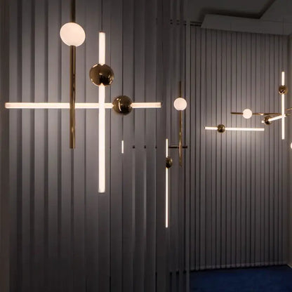 Modern brass pendant lights with gold-finished metal arms and spherical glass pendant shades for dining room use