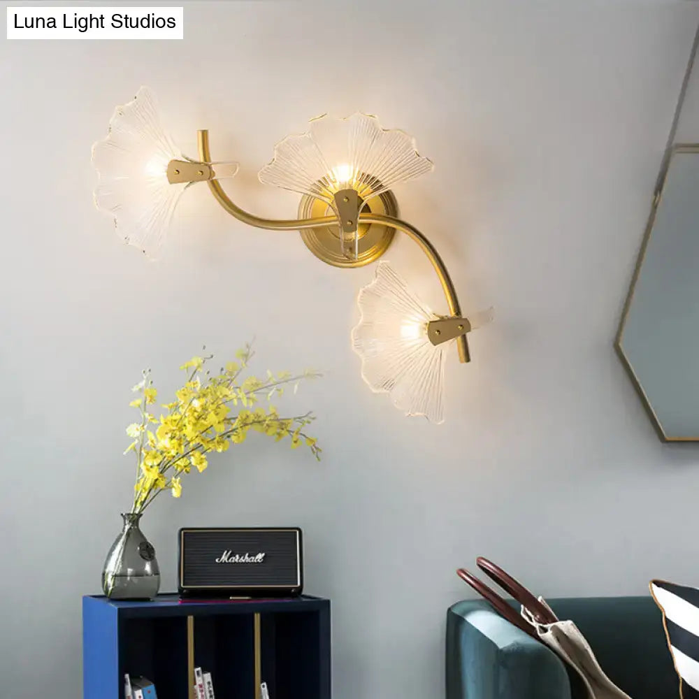 Modern brass ginkgo leaves wall light featuring a gold-toned sconce with three translucent fan-shaped glass shades