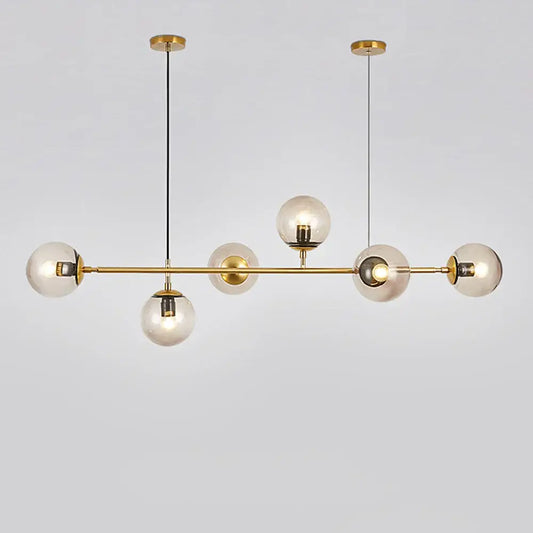 Modern brass glass ball led chandelier with five clear glass globe bulbs suspended by black cords for dining room decorbites