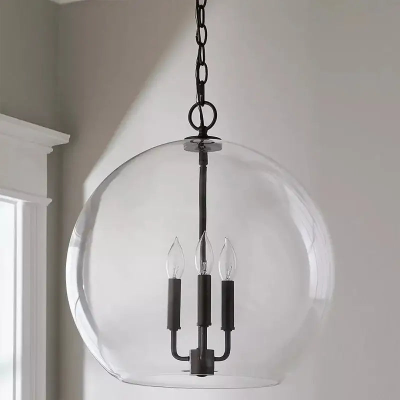 Black metal ball led chandelier with clear glass globe and three candle-style bulbs for dining room decorbites glass ball