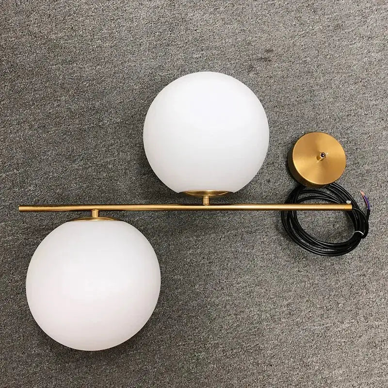 Modern brass glass ball led chandelier with gold-toned wall sconce and two frosted white spherical glass shades