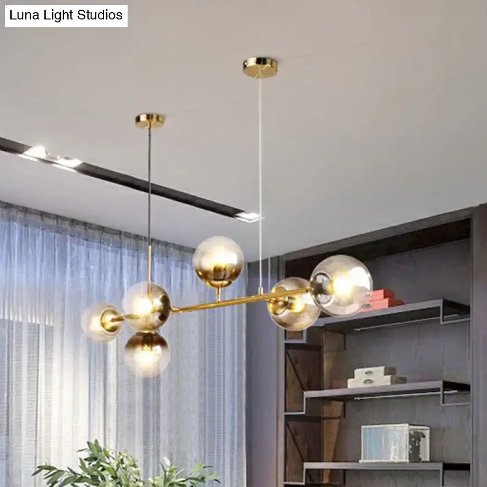 DecorBites™ 6-light linear dining room pendant with brass finish and smoke gray glass ball shades in minimalist design