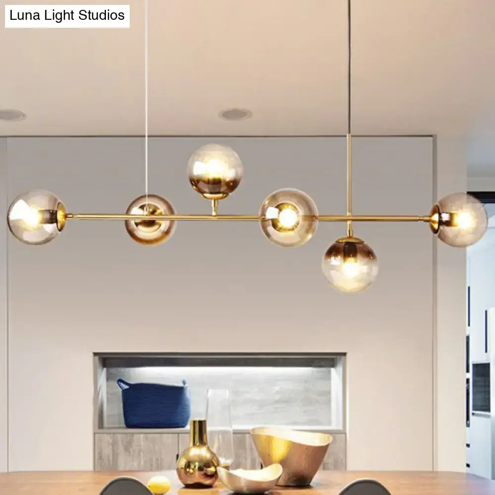 Gold-toned DecorBites 6-light linear dining room pendant with sleek bar and smoke gray glass ball shades