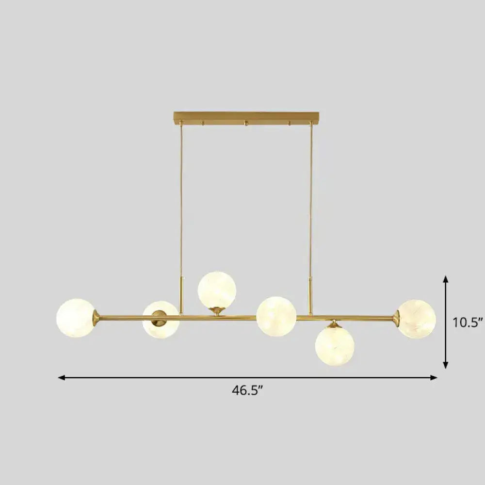 Decorbites 6-light linear dining room pendant with gold-toned metal finish and frosted glass ball shades