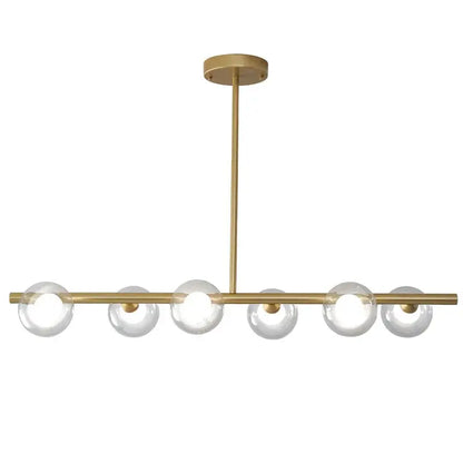 Modern brass glass ball pendant chandelier featuring six clear glass globe bulbs in a linear design for dining room decorbites glass ball
