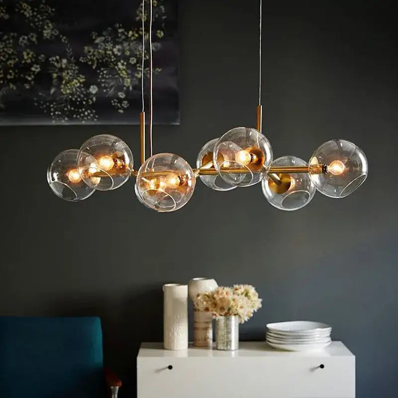 Modern brass glass ball pendant light featuring clear glass globe and warm glowing bulbs ideal for kitchen decorbites decor