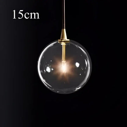 Modern brass glass ball pendant light with a clear glass globe and brass fixture for kitchen decorbites pendant light