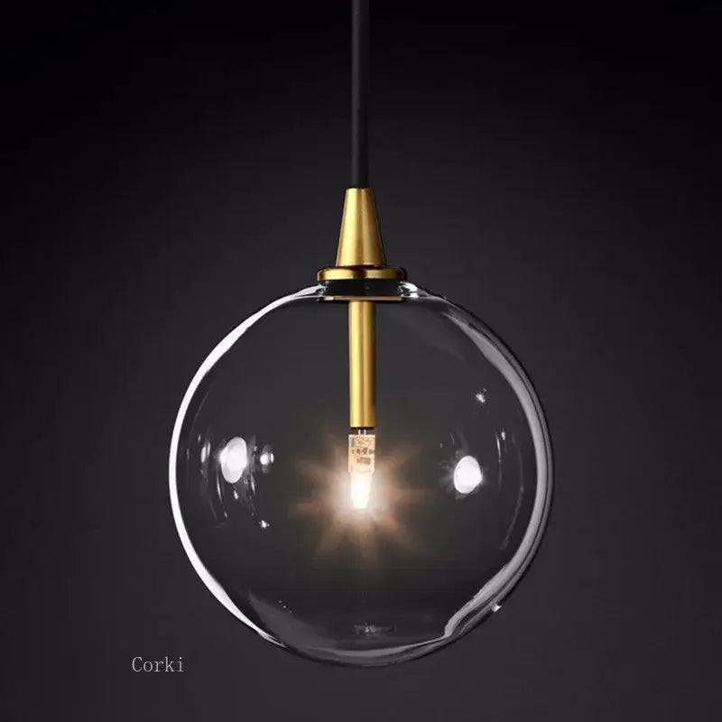 Modern brass glass ball pendant light with clear glass globe, brass fixture, and black cord for kitchen decorbites pendant light