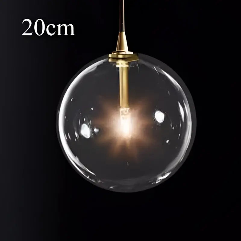 A sleek 20cm brass finish glass ball pendant light with exposed bulb ideal for modern kitchen decorbites decor