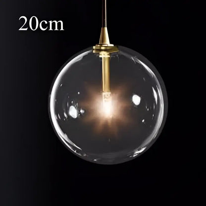 A sleek 20cm brass finish glass ball pendant light with exposed bulb ideal for modern kitchen decorbites decor