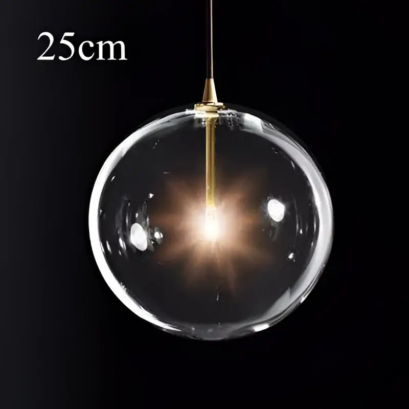 Modern brass glass ball pendant light with gold-toned metal fixture and illuminated decorbites glass ball pendant inside
