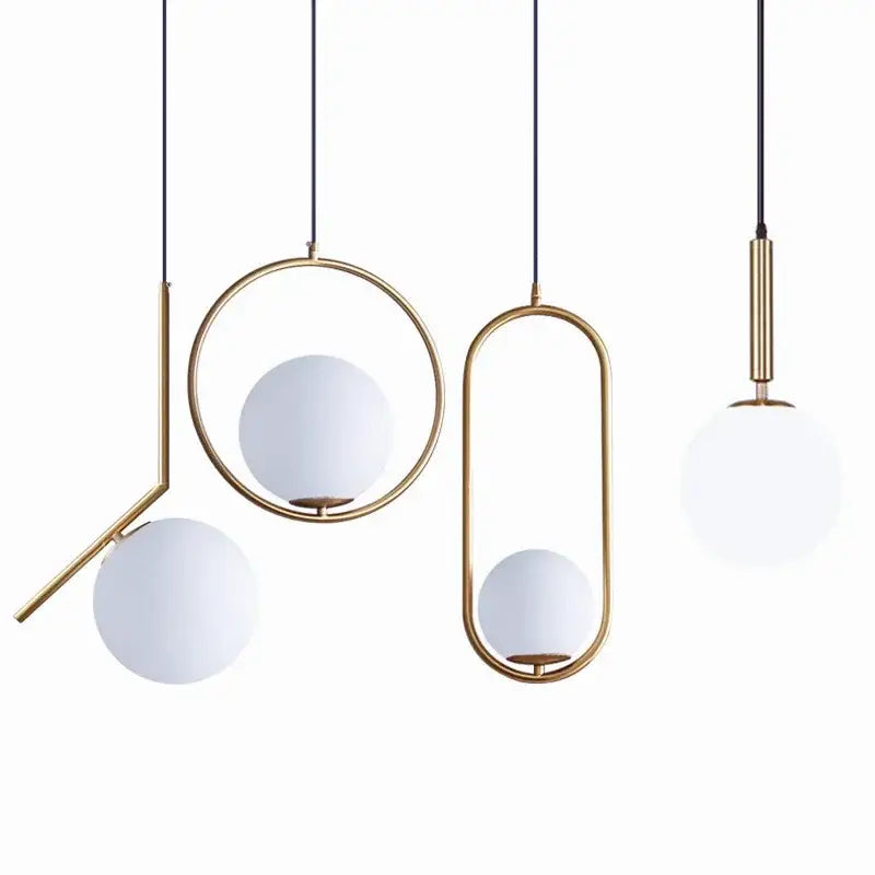 Modern brass glass ball pendant lights with frosted white spherical shades for kitchen decor by decorbites
