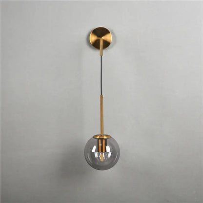 Modern brass glass ball wall lamp with gold-toned spherical pendant, smoked glass globe, and minimalist brass hardware for decorbites wall lamp