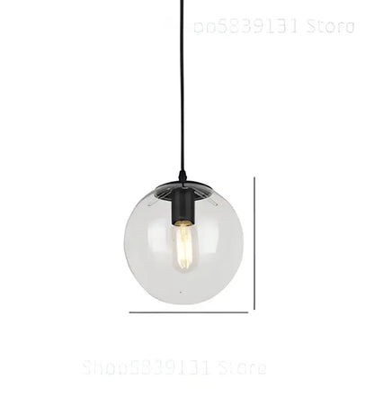 Modern brass glass ball wall lamps featuring a clear glass globe pendant light with black metal fixture and exposed bulb