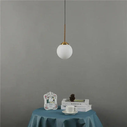 Minimalist modern brass glass ball wall lamps featuring a frosted white glass globe and slender brass stem for bedroom decorbites glass ball pendant light