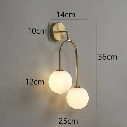 Modern brass glass ball wall lamps featuring two frosted glass globe shades for elegant bedroom lighting decorbites glass ball wall