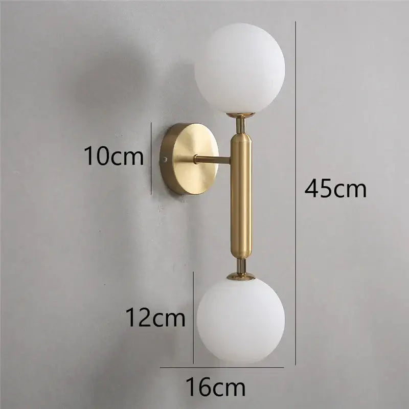 Modern brass glass ball wall lamps with two frosted white spherical shades for stylish bedroom sconce lighting decorbites
