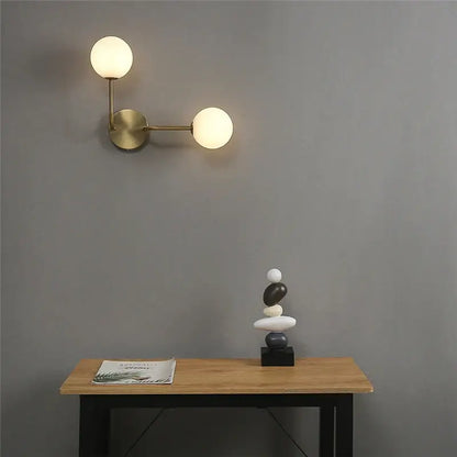 Modern brass glass ball wall lamps featuring two spherical frosted glass shades for bedroom decorbites lighting