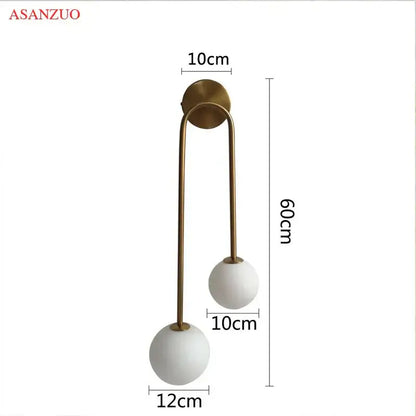 Modern brass glass ball wall sconce with two white matte glass globes and slender brass arms by asanzuo