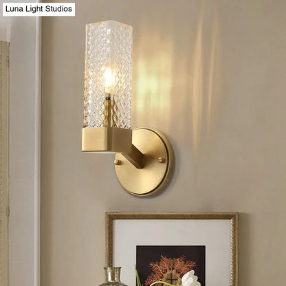 A modern wall lamp with textured clear glass cubic cylinder and brushed brass finish for e12 e14 bulbs