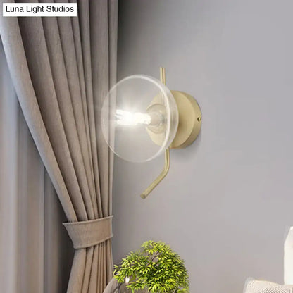 Modern brass glass dome wall sconce with gold arm and clear glass dome shade for bedroom lighting