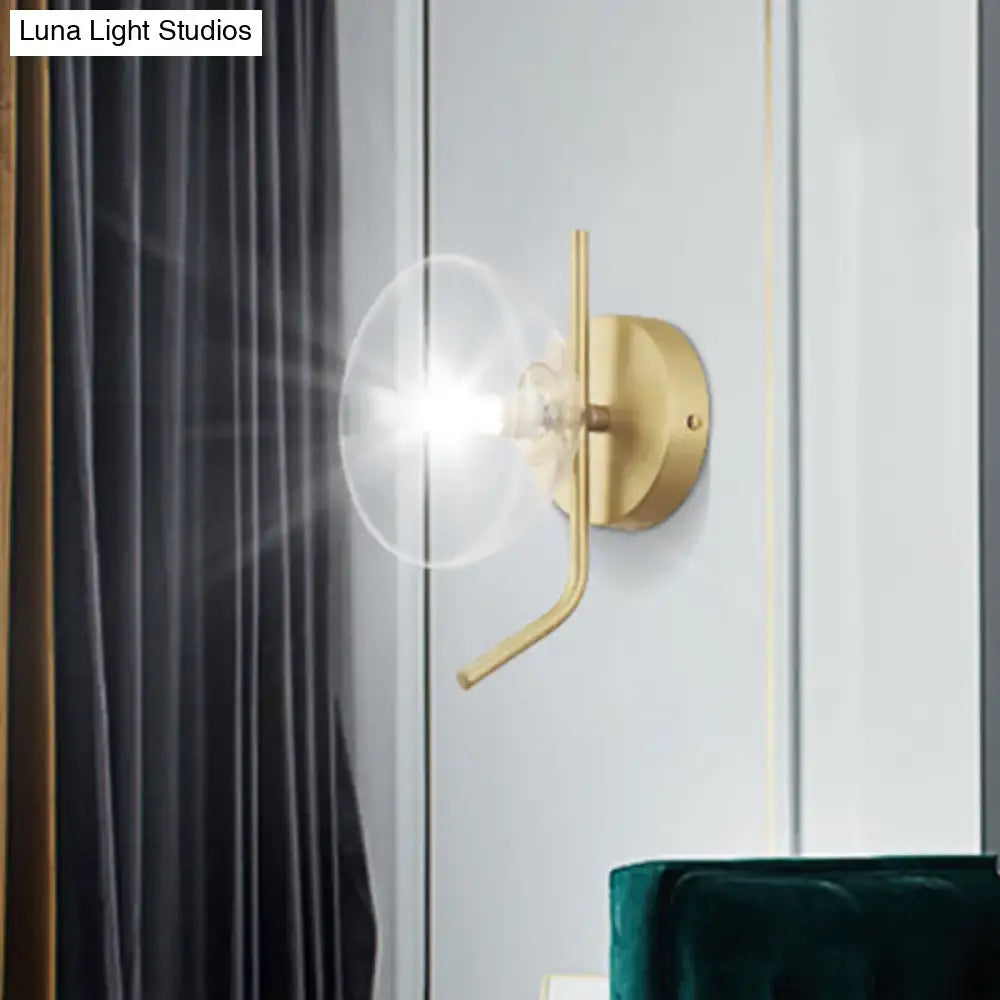 Modern brass glass dome wall sconce with gold arm and clear glass dome for elegant bedroom lighting