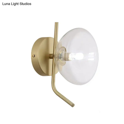 Modern brass glass dome wall sconce with gold arm and translucent glass dome for bedroom lighting