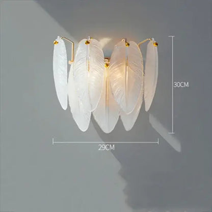 Elegant white feather chandelier wall sconce with gold-toned brass accents for modern dining room decor