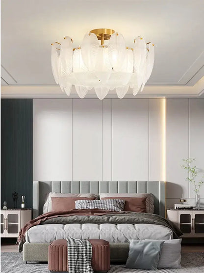 Modern brass glass feather chandelier with white feather-shaped glass and gold-toned central fixture for dining room