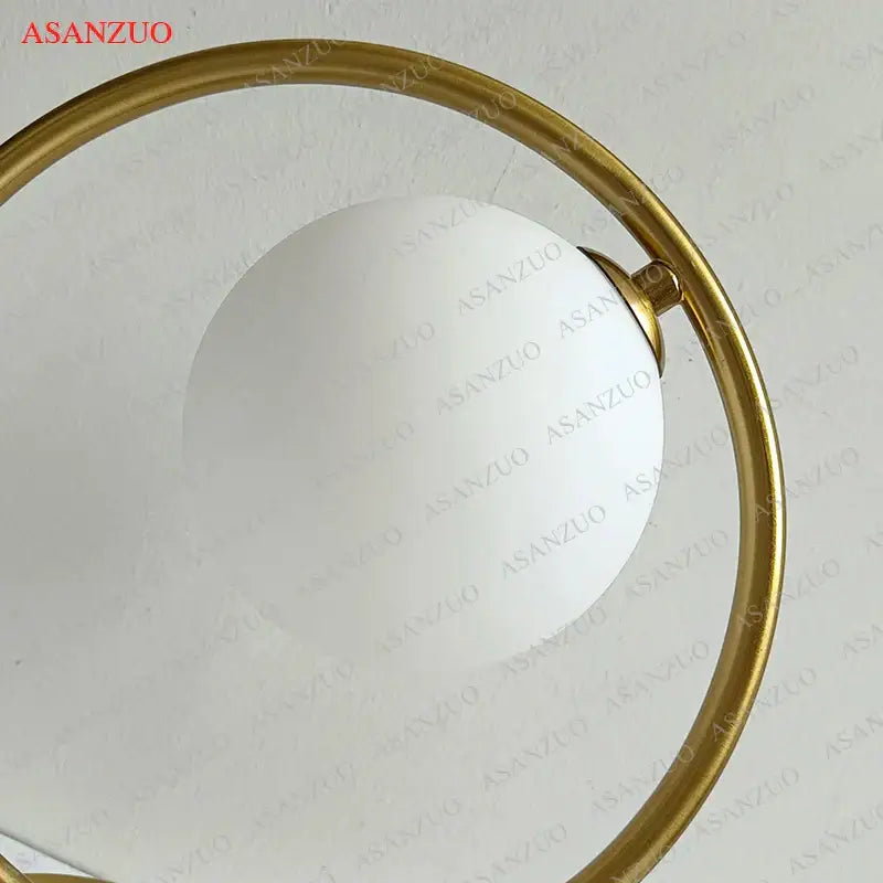 Modern brass glass led table lamp with gold-toned circular frame and frosted white spherical glass shade for reading desk decorbites brass glass