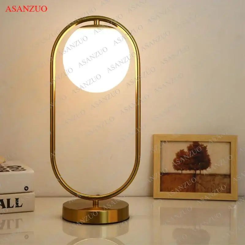 Modern brass glass led table lamp with gold-toned oval frame and circular illuminated panel for bedroom reading desk decorbites brass glass