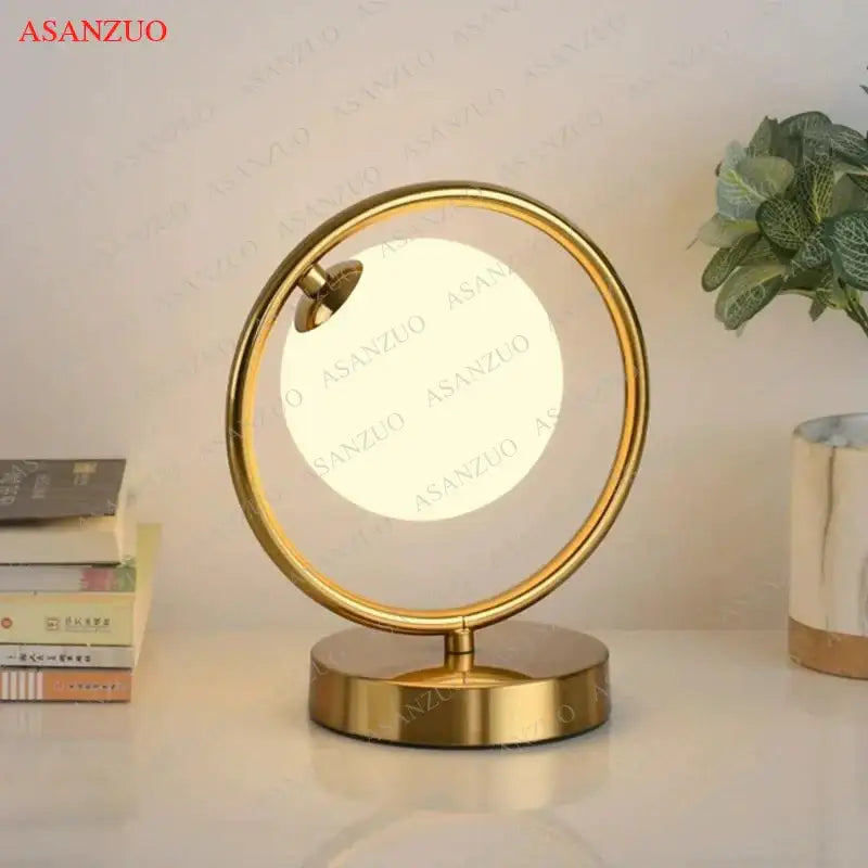 Gold-toned circular vanity mirror with integrated led lighting and modern design complements decorbites brass glass led table lamp