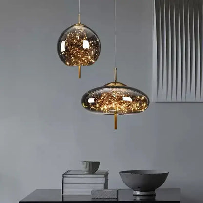 Modern brass glass pendant light with amber glass and warm fairy lights featuring spherical and oval shapes
