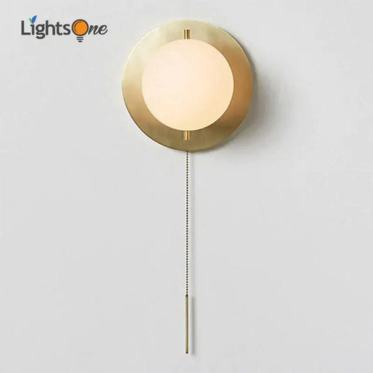 Modern brass glass round wall lamp with gold-toned circular sconce frosted globe and pull chain switch for bedroom